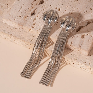Close-up of elegant silver tassel earrings with geometric metal dome and snake chain detail