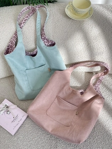 Chic leopard print corduroy tote bag in mint green and pink colors displayed on faux fur