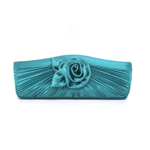 Detail of teal satin evening clutch featuring pleated fabric and a large 3D rose flower