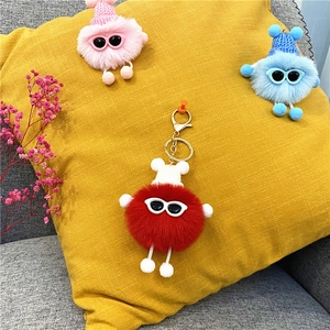 Close-up of fluffy soot sprite plush charms in red, pink and blue with sunglasses