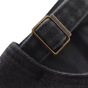 Detail of vintage copper metal buckle and charcoal gray washed cotton fabric on baseball cap