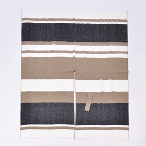Detailed flat lay of striped shawl featuring black, brown, and beige woven texture