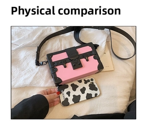 Top view of pink and black color-block box bag next to a phone for size reference