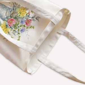 Off-white canvas tote bag featuring vibrant watercolor floral print with shoulder straps