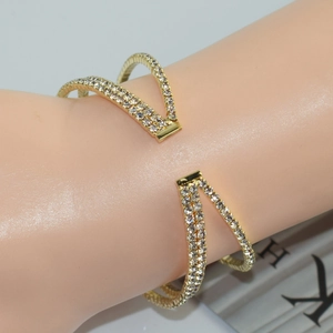 Detail of luxury gold crisscross bracelet with pavé rhinestones on a female wrist
