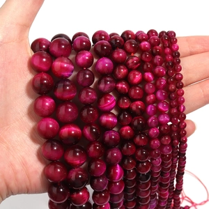 Macro detail of natural pink tiger eye beads in various sizes for DIY jewelry making