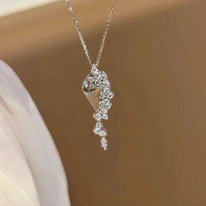 Macro detail of hourglass pendant with shimmering crystals on a silver chain necklace