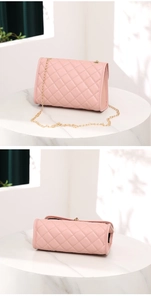 Detail of pink quilted crossbody bag with gold chain strap and cat-shaped tassel pendant