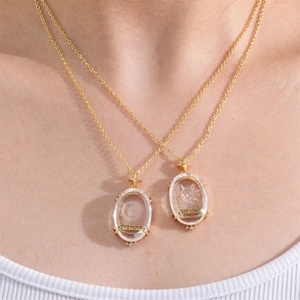 Close-up of gold tarot necklaces featuring The Moon and Death crystal pendants on a model