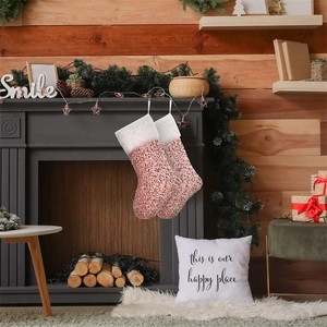 Calze di Natale con paillettes rosa e polsini in peluche appese al caminetto