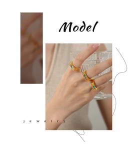 Close-up of three gold-plated wide rings with blue and purple heart-shaped zircon stones