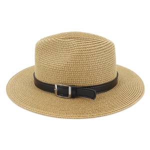 Detailed view of woven straw sun hat texture with black faux leather band and silver buckle