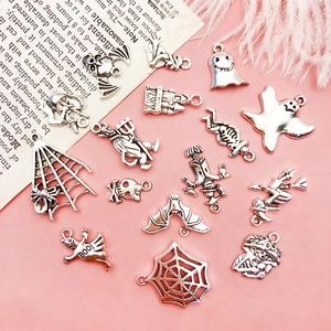 Flat lay of vintage silver Halloween skull and ghost charms for DIY jewelry making