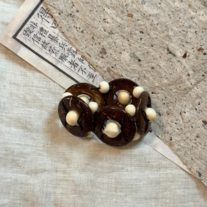 Detailed view of bohemian coconut shell and wood bead elastic bracelet on burlap background