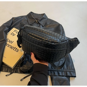 Detail of black woven PU leather chest bag with adjustable strap and textured zipper