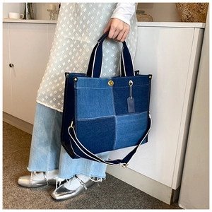 Détail du sac cabas en denim patchwork bleu avec garnitures métalliques et bandoulière