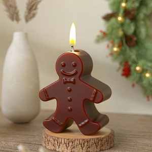 Gingerbread man candle on a wood base with Christmas wreath and festive decor