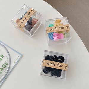 Détails de petites pinces à cheveux en plastique colorées dans leurs boîtes cadeaux