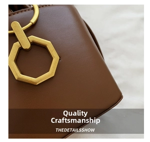 Detail of vintage brown leather handbag with antique gold octagonal metal clasp hardware