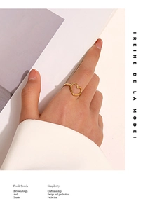 Detail of elegant hollow heart ring in gold finish worn on a finger for a minimalist look
