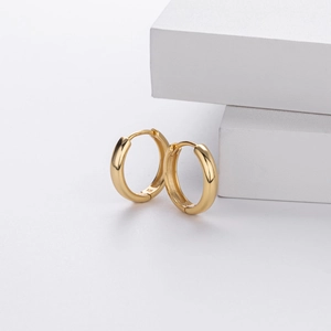 Detailed macro view of 925 silver stamp on minimalist gold-plated hoop earrings