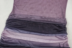 Detail of purple gradient sheer mesh fabric with ruched side stitching on fitted dress
