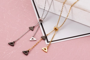 Detailed view of silver and gold Y-shaped necklaces with geometric triangle pendants