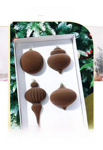 Close-up of four brown velvet Christmas ornaments with vertical stripes in a gift box
