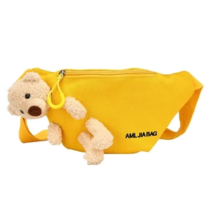 Bright yellow canvas sling bag for girls with cute 3D plush bear mascot on white background