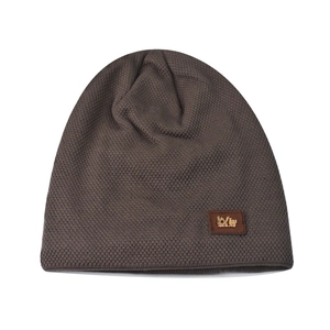 Detail of winter beanie featuring a warm knitted texture and a premium leather logo patch