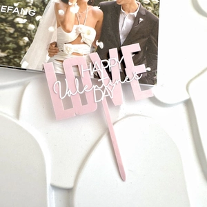 Dettaglio di un cake topper Love in acrilico a doppio strato rosa e bianco per San Valentino