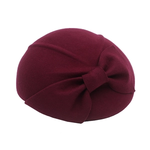 Detail view of the elegant wine red wool beret with a decorative vintage bow tie