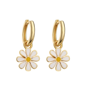 Golden hoop earrings with white daisy enamel charms on a clean white background