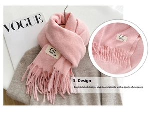 Close-up of pink cashmere-like scarf with fringe details and woven label decoration