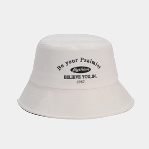Close-up of white bucket hat featuring black letter printing and precise brim stitching