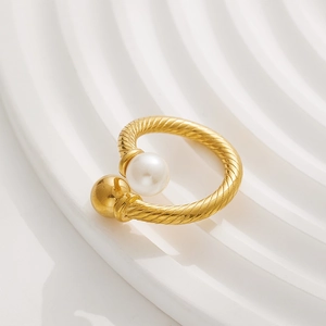 Detailed shot of gold-plated twisted band ring featuring a pearl and gold bead accent