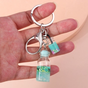 Close-up of a blue mini drink bottle keychain with lemon slices and colorful beads