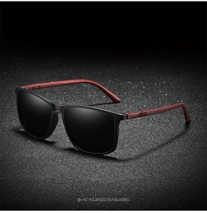 Detail view of polarized sunglasses with black frame and textured red temple arms