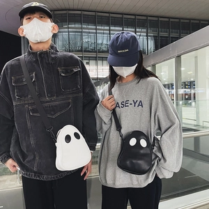 Street style shot of black and white ghost-shaped PU crossbody bags for couples