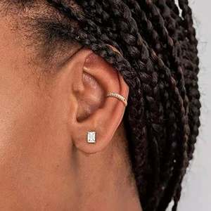 Detail showing an emerald cut clear stud earring and crystal ear cuff on model ear