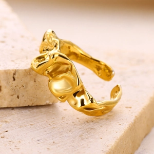 Macro shot of gold adjustable ring featuring irregular molten texture on stone background