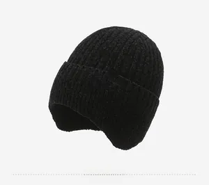 Detail view of thick black knitted ear-flap beanie with Sport label for winter warmth