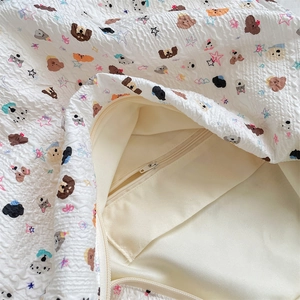 Détail du sac en toile matelassé avec poche intérieure zippée et motifs de chiens