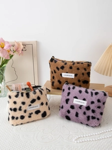 Detailed view of leopard print plush makeup bags in brown, beige, and purple tones