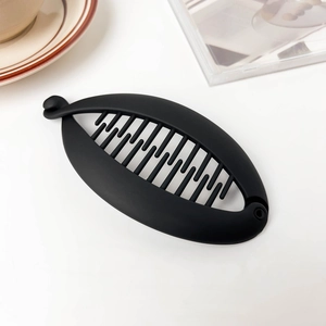 Detail showing the inner teeth and matte texture of the black banana hair clip