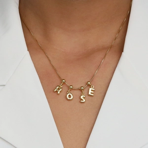 Elegant 18k gold plated bubble letter necklace with ROSE pendant on a model wearing white
