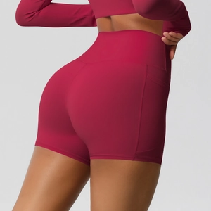 Detail of high-waisted yoga shorts with side pocket and peach lift effect in burgundy