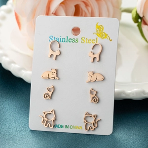 Set of four pairs of rose gold stainless steel cat stud earrings on a white display card
