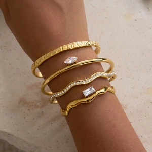 Stacked 18K gold plated stainless steel bangles with marquise cubic zirconia on stone base
