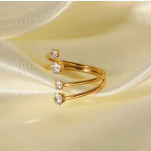 Detail of gold double spiral ring featuring four-prong set white zircon stones